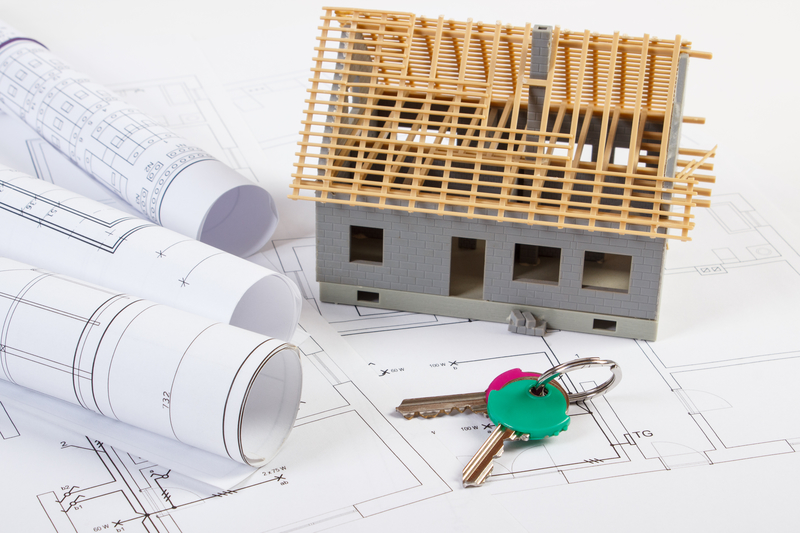 Home keys, small house under construction and electrical drawings, building home concept